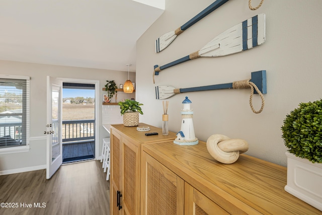 doorway to outside with wood finished floors and baseboards