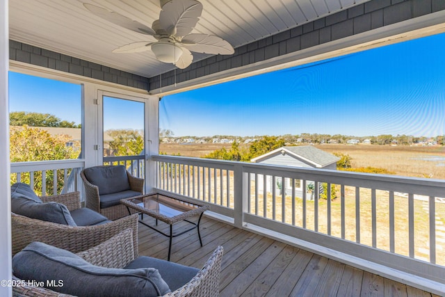 wooden terrace with an outdoor hangout area and ceiling fan