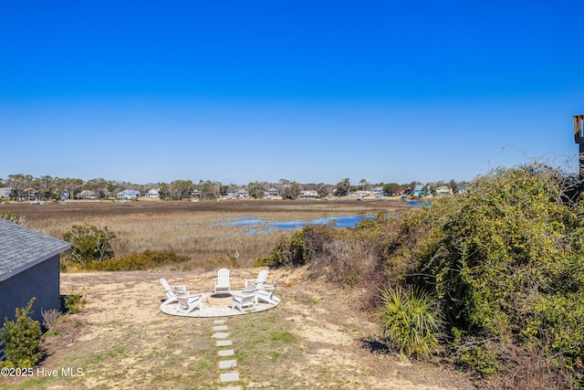 view of yard featuring a fire pit and a water view