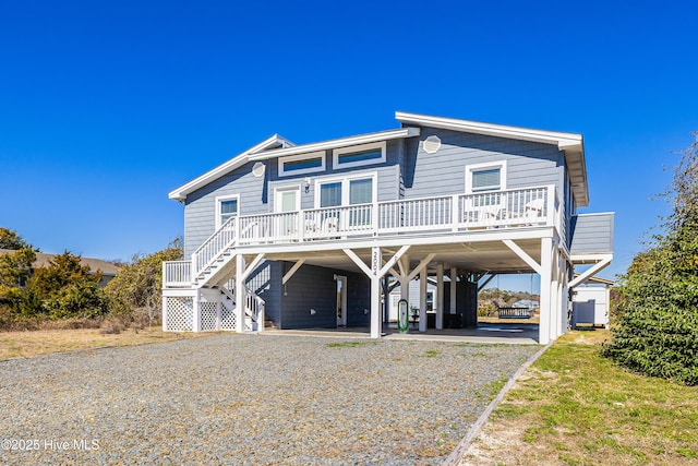 view of front of property with a carport, stairway, driveway, and covered porch