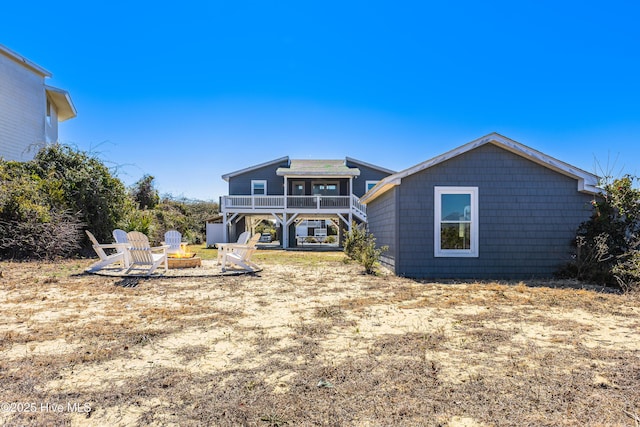 back of property with stairway, a fire pit, and a deck