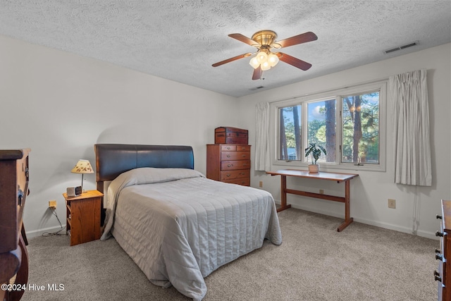 carpeted bedroom featuring baseboards, a textured ceiling, ceiling fan, and visible vents