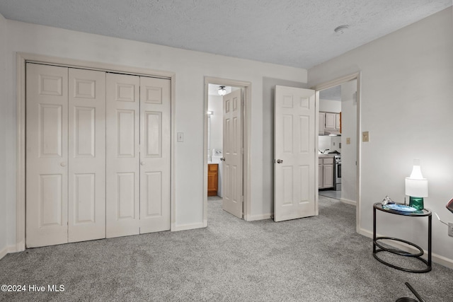 unfurnished bedroom with a closet, carpet flooring, and a textured ceiling