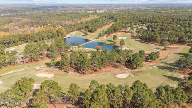 aerial view featuring a water view, view of golf course, and a forest view