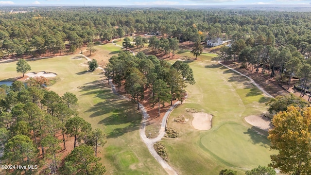birds eye view of property with golf course view and a forest view