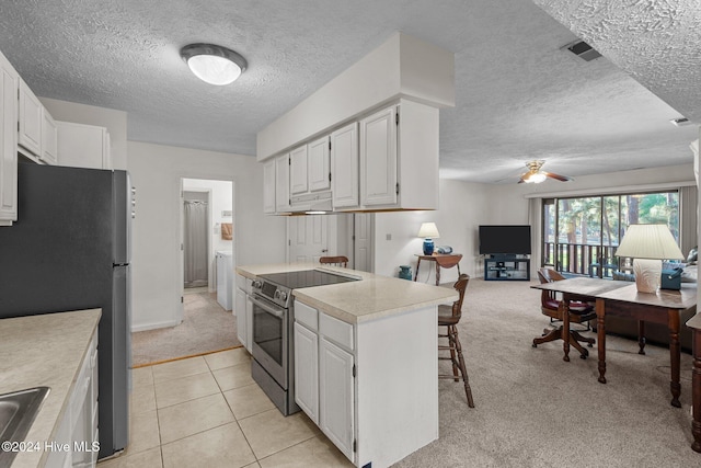 kitchen with light countertops, light carpet, white cabinetry, stainless steel appliances, and ceiling fan