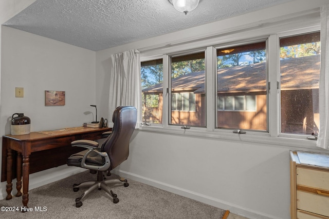 carpeted office with baseboards and a textured ceiling