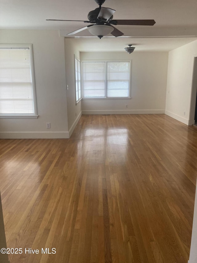 spare room with ceiling fan, baseboards, and wood finished floors