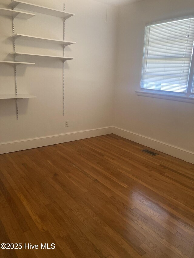 empty room with wood finished floors and baseboards