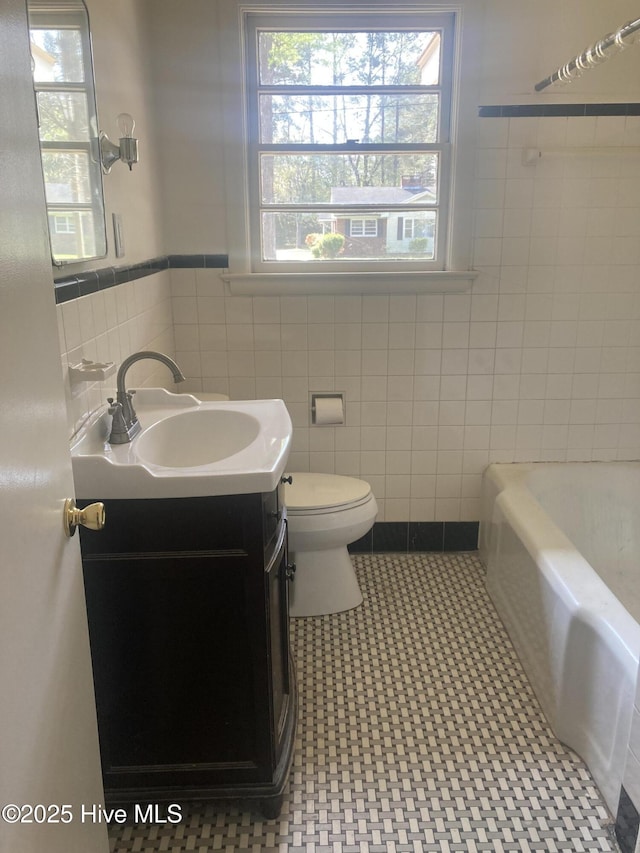 clothes washing area with independent washer and dryer, light tile patterned flooring, and baseboards