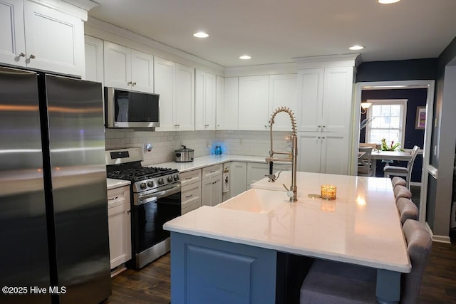 1714 Pine St, Elizabeth City, NC 27909 - kitchen featuring a kitchen bar, dark wood-style flooring, decorative backsplash, white cabinets, and appliances with stainless steel finishes