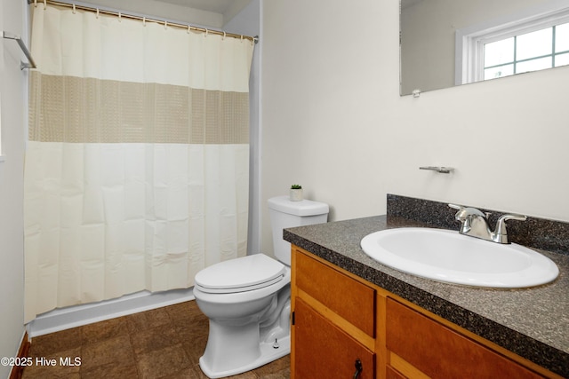 bathroom with curtained shower, vanity, and toilet