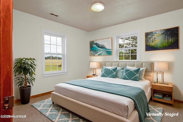 bedroom featuring carpet flooring, baseboards, multiple windows, and visible vents
