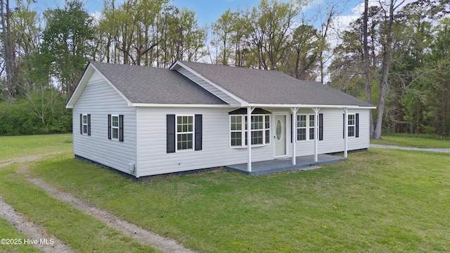 view of front of property featuring a shingled roof and a front yard