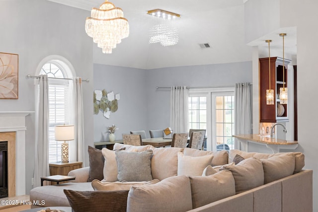 1096 Rutledge Ct NW, Calabash, NC 28467 - living area featuring a chandelier, plenty of natural light, a premium fireplace, and high vaulted ceiling