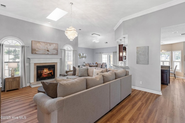 1096 Rutledge Ct NW, Calabash, NC 28467 - living room with a glass covered fireplace, wood finished floors, plenty of natural light, a skylight, and ornamental molding