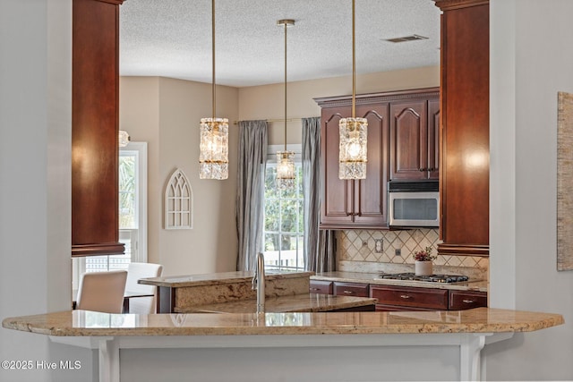 1096 Rutledge Ct NW, Calabash, NC 28467 - kitchen with stainless steel appliances, backsplash, light stone countertops, a textured ceiling, and pendant lighting