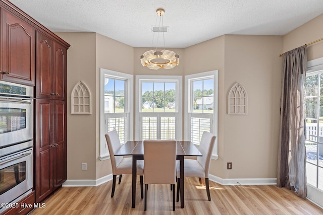 1096 Rutledge Ct NW, Calabash, NC 28467 - dining space with light wood-style floors, a chandelier, baseboards, and a textured ceiling