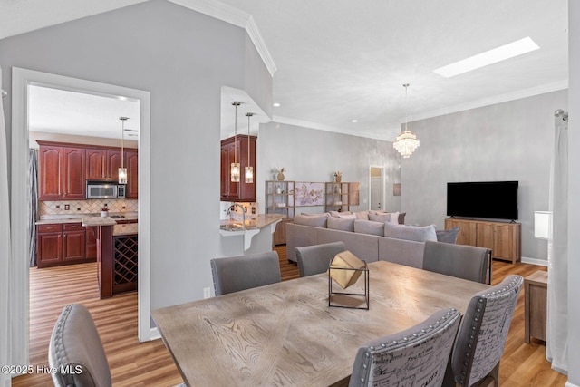 1096 Rutledge Ct NW, Calabash, NC 28467 - dining room featuring light wood-style floors, crown molding, a chandelier, recessed lighting, and a skylight
