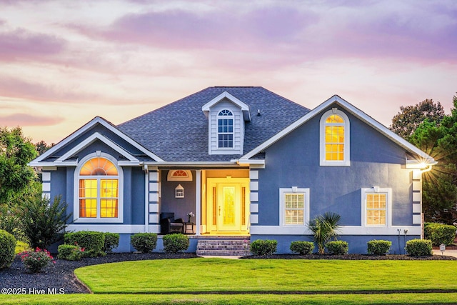 1096 Rutledge Ct NW, Calabash, NC 28467 - view of front of home featuring stucco siding, roof with shingles, a front yard, and covered porch
