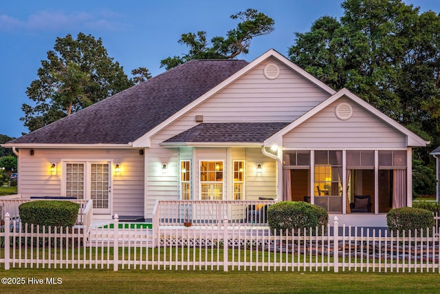 1096 Rutledge Ct NW, Calabash, NC 28467 - view of front facade with a sunroom, a fenced front yard, and a shingled roof