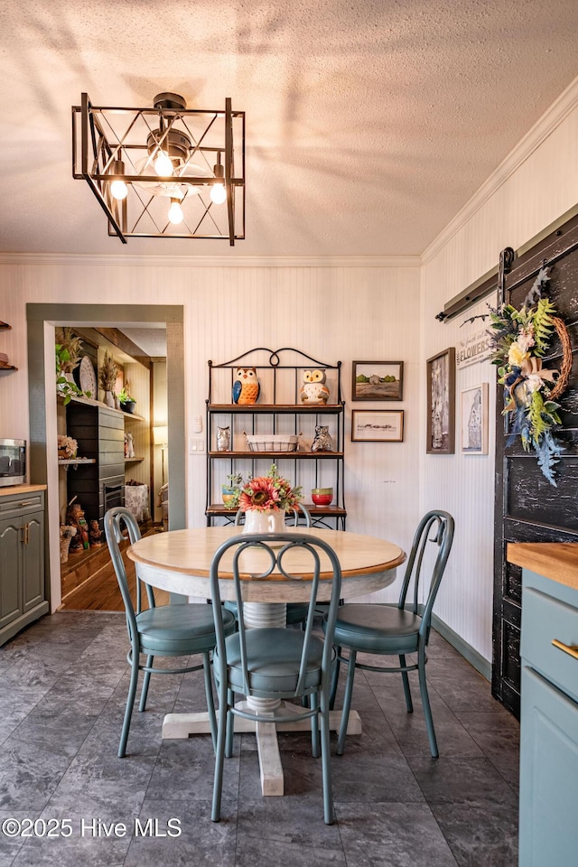 dining space featuring a fireplace, ornamental molding, and a textured ceiling