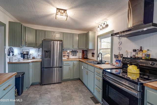 kitchen with stainless steel refrigerator with ice dispenser, a sink, butcher block counters, range with electric cooktop, and wall chimney exhaust hood
