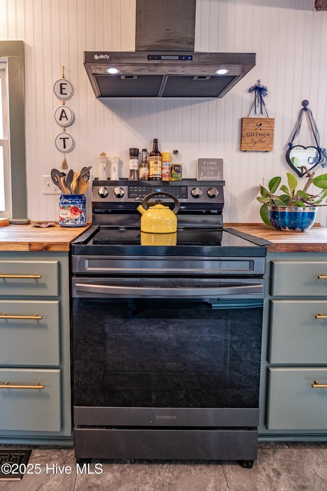 kitchen with wooden counters, gray cabinetry, stainless steel range with electric cooktop, and under cabinet range hood