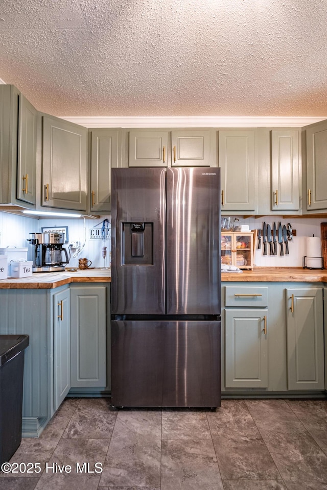 kitchen featuring wooden counters, stainless steel fridge, gray cabinetry, and a textured ceiling