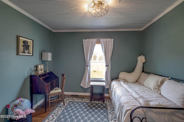 bedroom featuring crown molding, baseboards, and wood finished floors