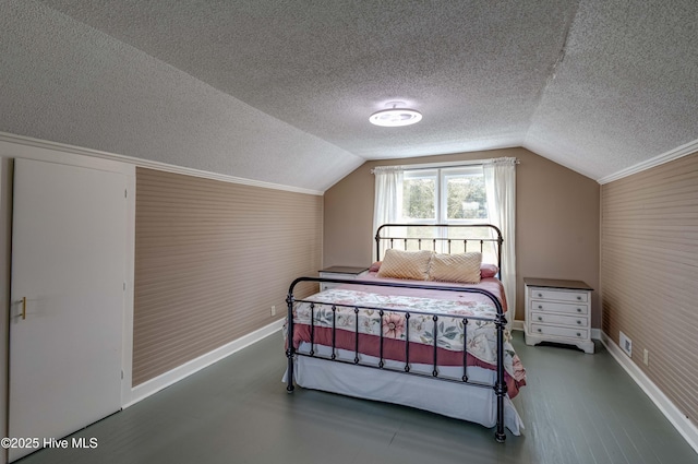 bedroom featuring baseboards, vaulted ceiling, wood finished floors, and a textured ceiling