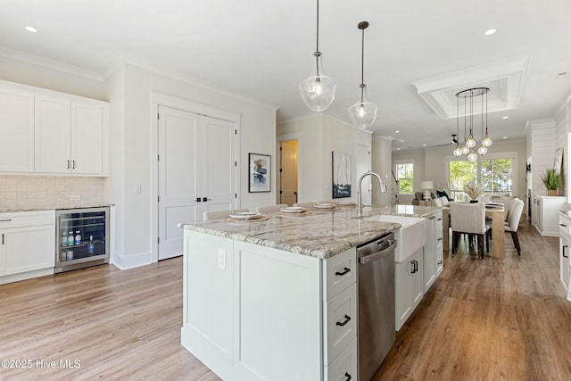 kitchen with a sink, light wood finished floors, white cabinetry, stainless steel dishwasher, and beverage cooler