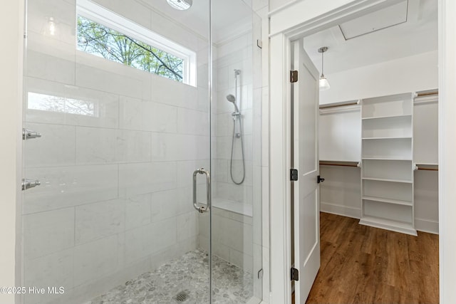 bathroom with wood finished floors and a shower stall