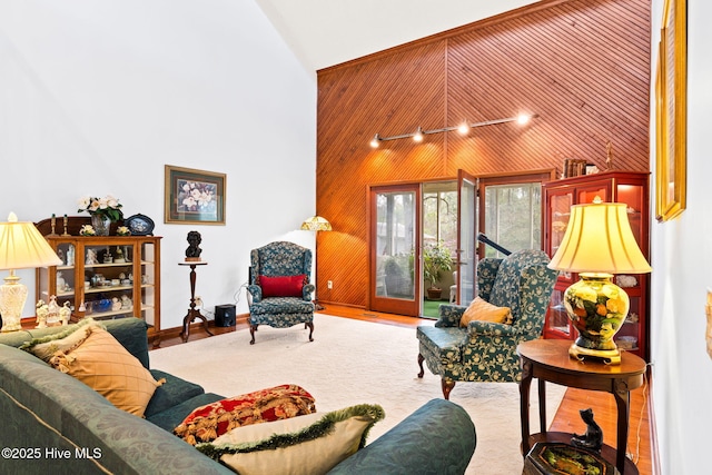 living room with high vaulted ceiling and wooden walls