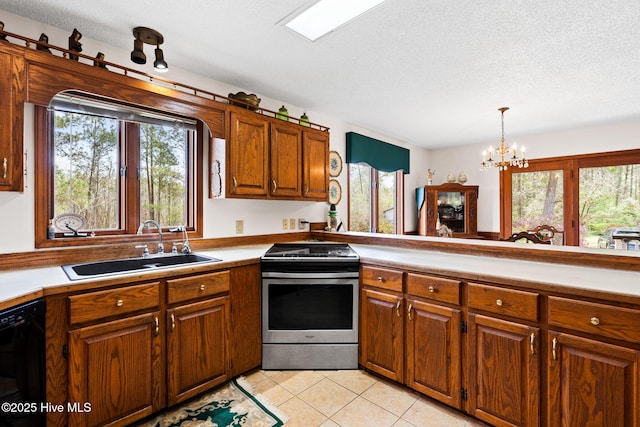kitchen featuring a wealth of natural light, stainless steel range with gas cooktop, black dishwasher, and a sink