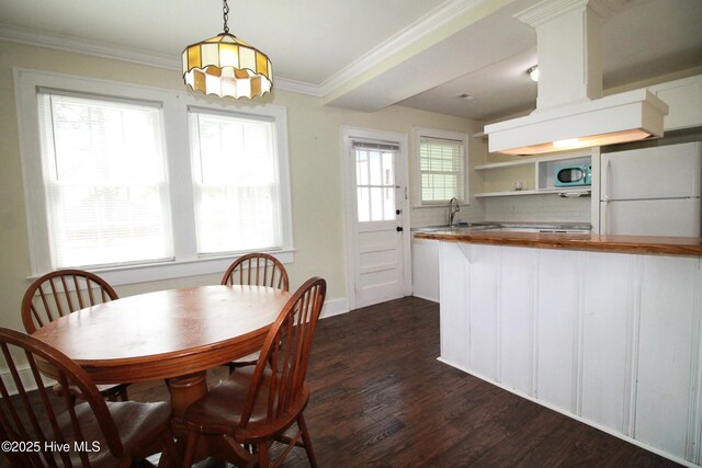 dining room featuring ornamental molding and dark wood finished floors