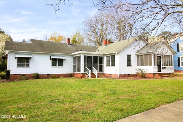 back of property featuring a sunroom, crawl space, a shingled roof, a yard, and a chimney