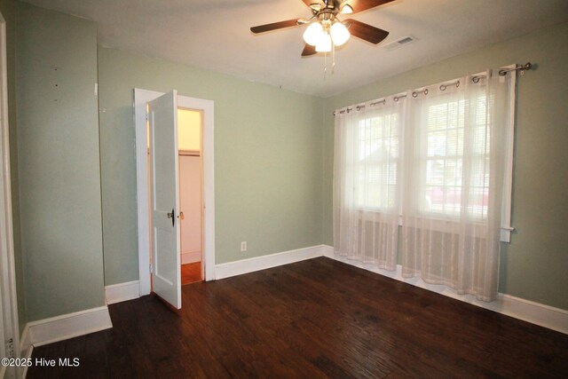 unfurnished bedroom featuring baseboards, visible vents, wood finished floors, and ceiling fan