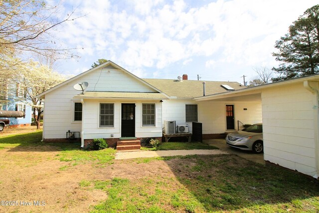 view of front facade with entry steps, a front yard, an attached carport, ac unit, and roof with shingles
