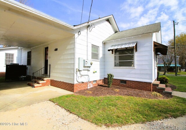 view of front of home featuring concrete driveway, crawl space, entry steps, an attached carport, and a shingled roof