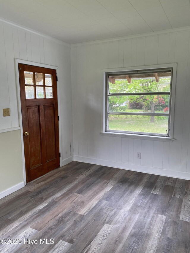 entrance foyer with dark wood-style floors, crown molding, and baseboards