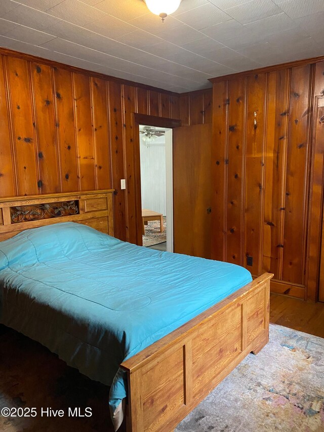 bedroom with wooden walls and wood finished floors