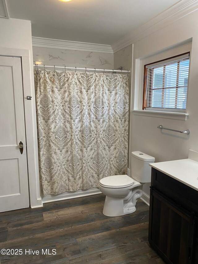 bathroom with a shower with shower curtain, ornamental molding, wood finished floors, toilet, and vanity