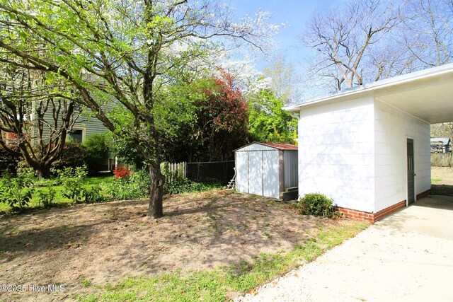 view of yard with a shed, an outbuilding, and fence