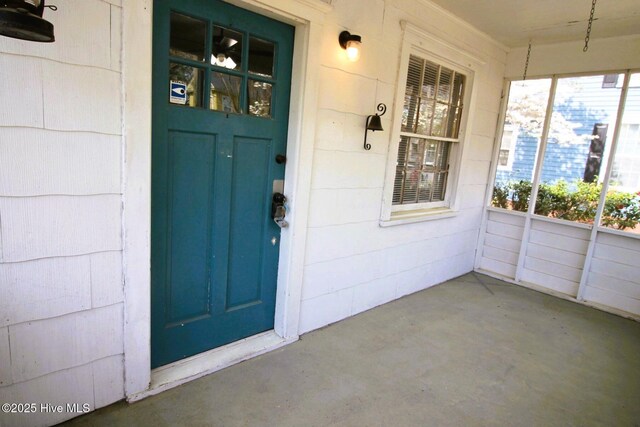 view of exterior entry featuring covered porch