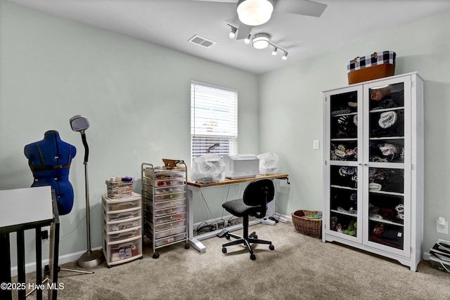 carpeted office space with baseboards, ceiling fan, and visible vents