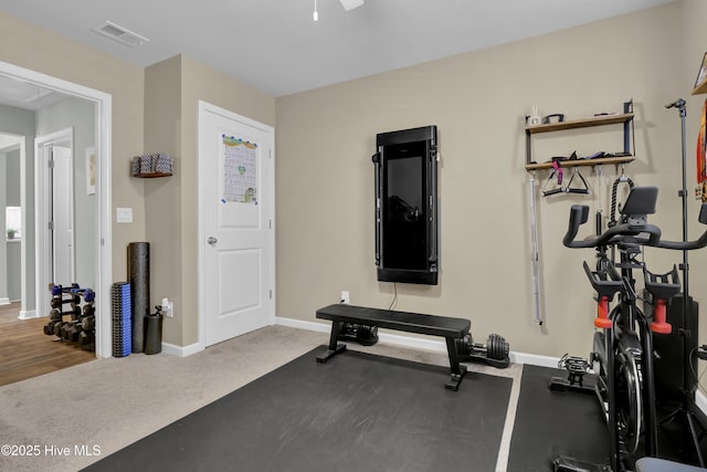 workout area featuring baseboards, carpet floors, ceiling fan, and visible vents