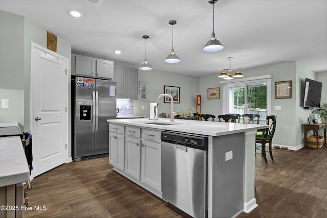 kitchen featuring a sink, light countertops, appliances with stainless steel finishes, and dark wood-style flooring