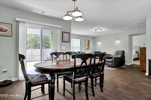 dining space featuring baseboards, visible vents, and dark wood finished floors