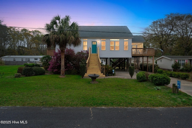 view of front of property with stairs, a shingled roof, a front yard, and a carport